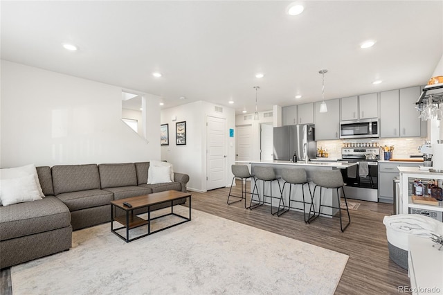 living room with wood finished floors and recessed lighting