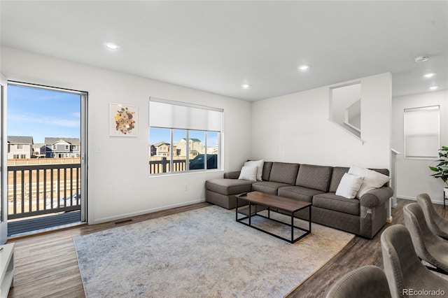 living room with visible vents, baseboards, wood finished floors, and recessed lighting