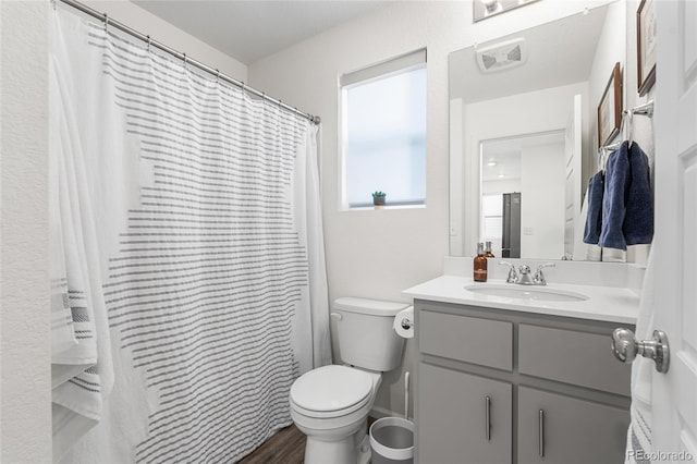 bathroom featuring toilet, wood finished floors, and vanity