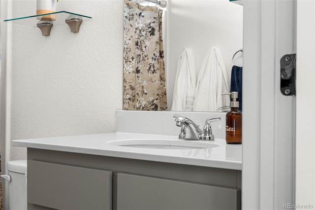 bathroom featuring a textured wall and vanity