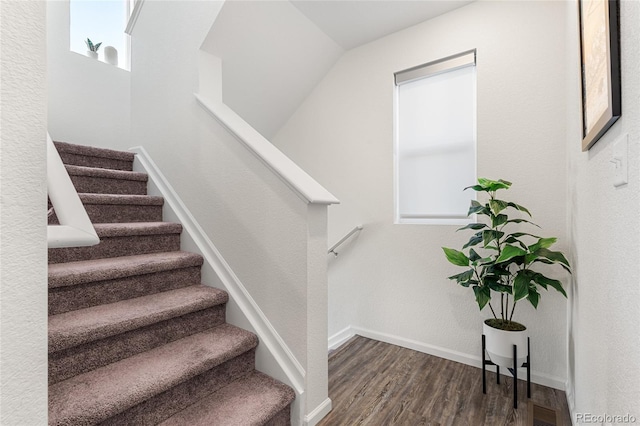 stairway with visible vents, baseboards, and wood finished floors