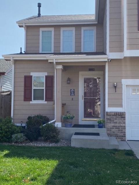 property entrance with a garage and a yard