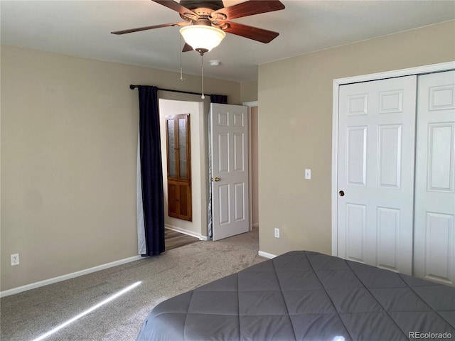 unfurnished bedroom with ceiling fan, carpet floors, a closet, and baseboards