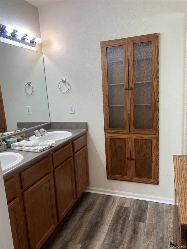 full bathroom featuring double vanity, a sink, and wood finished floors