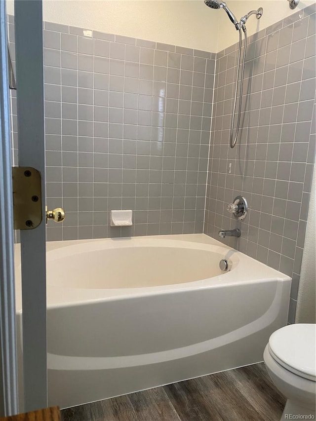 full bathroom featuring  shower combination, toilet, and wood finished floors