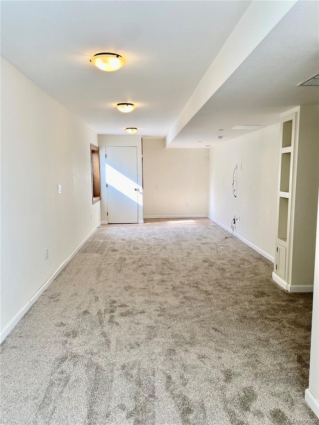 carpeted spare room featuring visible vents and baseboards