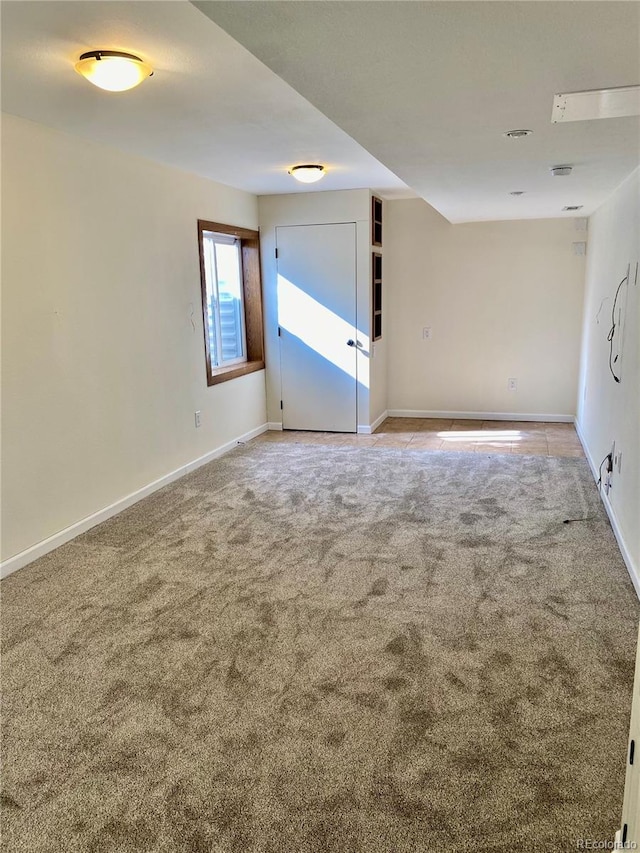 carpeted empty room featuring baseboards