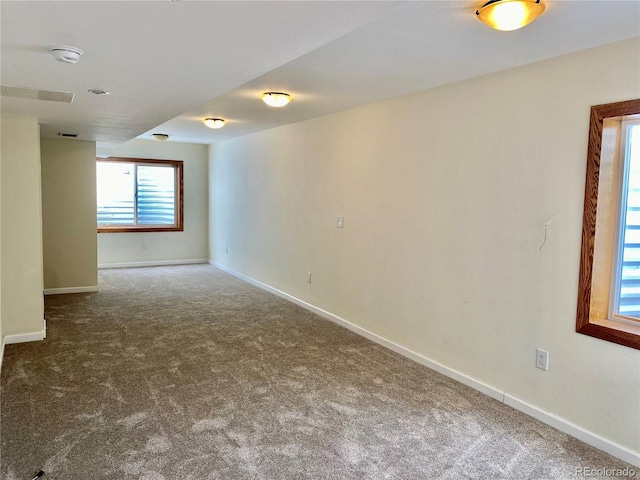 carpeted empty room featuring baseboards