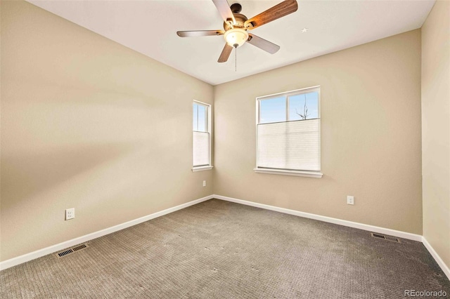 carpeted empty room featuring baseboards, visible vents, and a ceiling fan