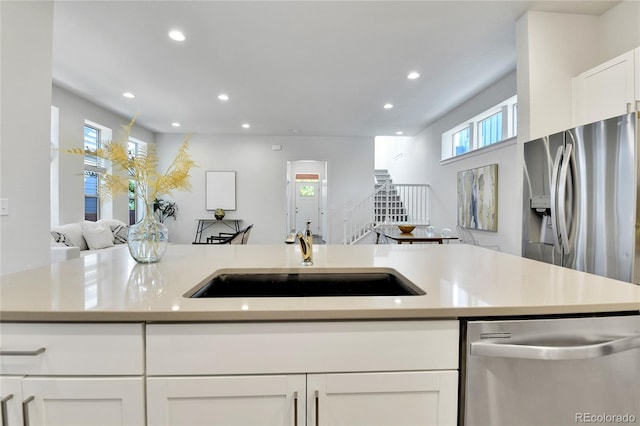 kitchen with white cabinets, appliances with stainless steel finishes, and sink