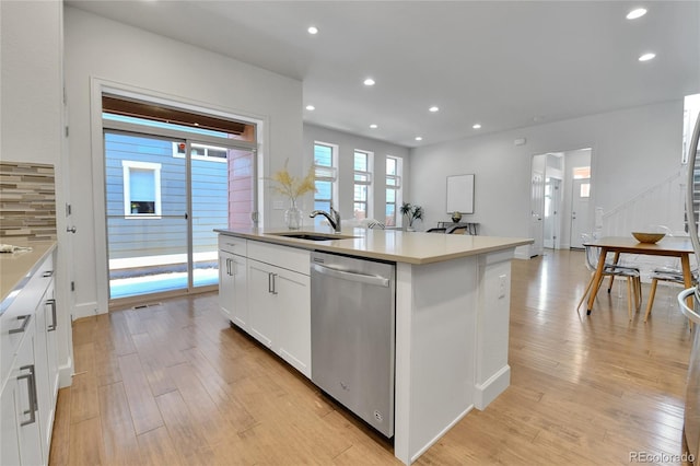 kitchen featuring sink, stainless steel dishwasher, a center island with sink, white cabinetry, and light wood-type flooring