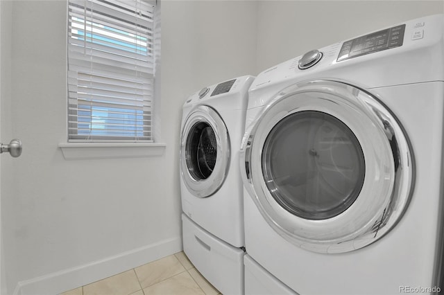 clothes washing area with independent washer and dryer and light tile patterned floors