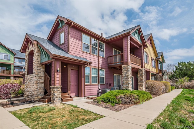 view of front of house featuring central AC unit and a balcony