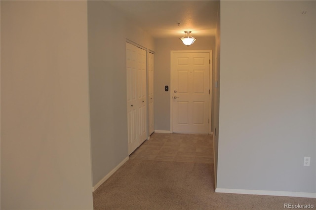 corridor featuring light colored carpet