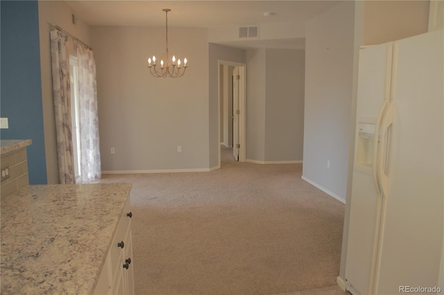 interior space with white fridge with ice dispenser, hanging light fixtures, light carpet, and a chandelier