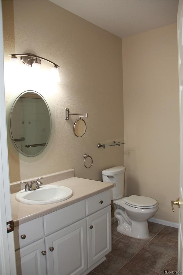 bathroom featuring tile patterned flooring, vanity, and toilet