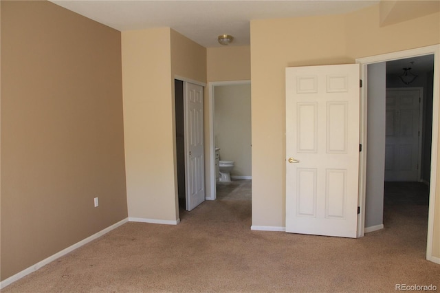 unfurnished bedroom with light carpet and ensuite bath