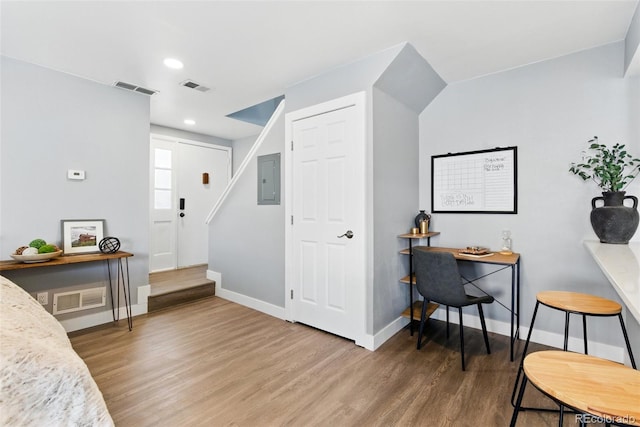 foyer entrance with electric panel, visible vents, baseboards, and wood finished floors