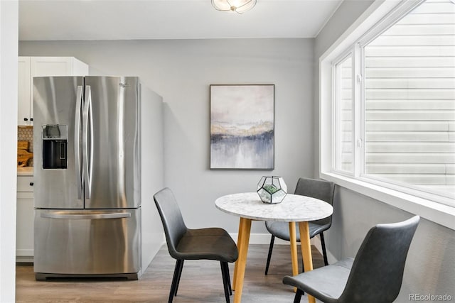 dining area featuring baseboards and light wood-style flooring