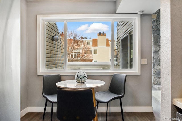 dining room featuring dark wood finished floors and baseboards