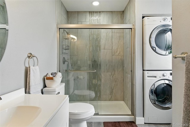 full bath with vanity, toilet, a shower stall, and stacked washing maching and dryer