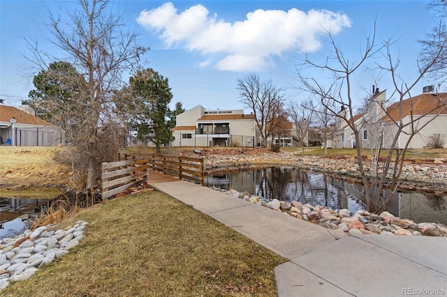 view of yard with a water view and fence