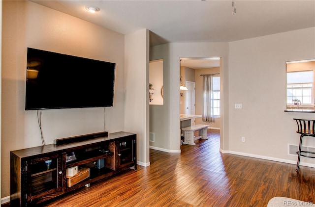 living room with visible vents, wood finished floors, and baseboards