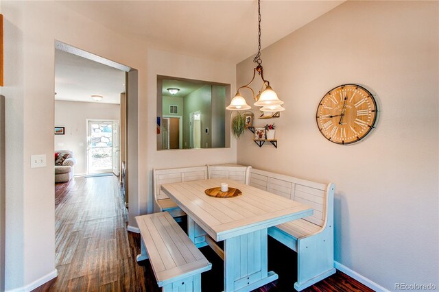 dining area with baseboards, breakfast area, visible vents, and dark wood-type flooring
