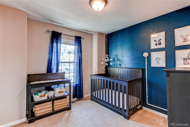 bedroom with carpet flooring, a nursery area, and baseboards