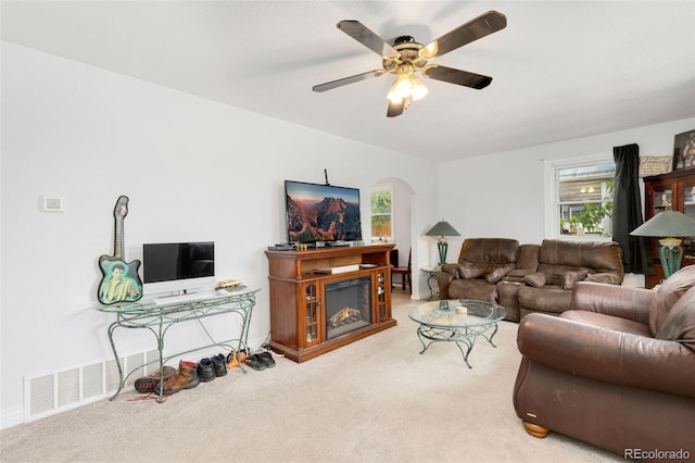 544 S 3rd Ave, Brighton, CO 80601 - carpeted living area with a ceiling fan, arched walkways, a glass covered fireplace, and baseboards