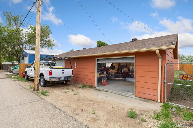544 S 3rd Ave, Brighton, CO 80601 - view of side of property featuring a garage, an outbuilding, and a gate