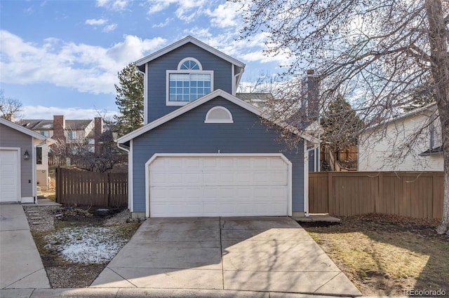 view of front of house with fence and concrete driveway