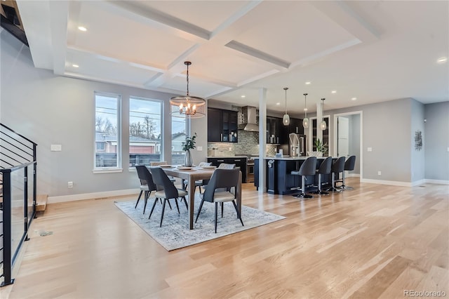 dining area featuring light wood finished floors, baseboards, and coffered ceiling