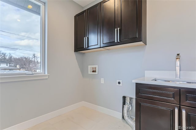 washroom with hookup for a washing machine, baseboards, cabinet space, electric dryer hookup, and a sink