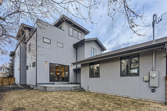 back of property with a yard, a patio area, fence, and stucco siding