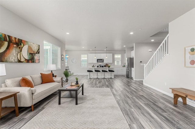 12941 Delaware St, Westminster, CO 80234 - living room featuring light wood-style flooring, baseboards, recessed lighting, and stairs