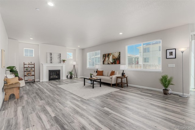 12941 Delaware St, Westminster, CO 80234 - living area featuring light wood-style floors, baseboards, healthy amount of natural light, a glass covered fireplace, and recessed lighting