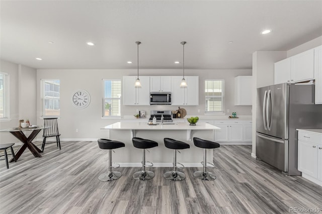12941 Delaware St, Westminster, CO 80234 - kitchen with appliances with stainless steel finishes, a kitchen bar, light countertops, healthy amount of natural light, and recessed lighting