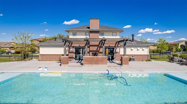 12941 Delaware St, Westminster, CO 80234 - back of property featuring a pergola, brick siding, a patio, fence, and a chimney