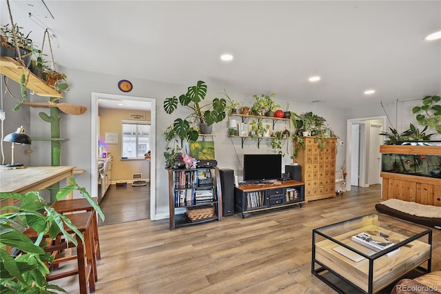 living area with visible vents, recessed lighting, and wood finished floors