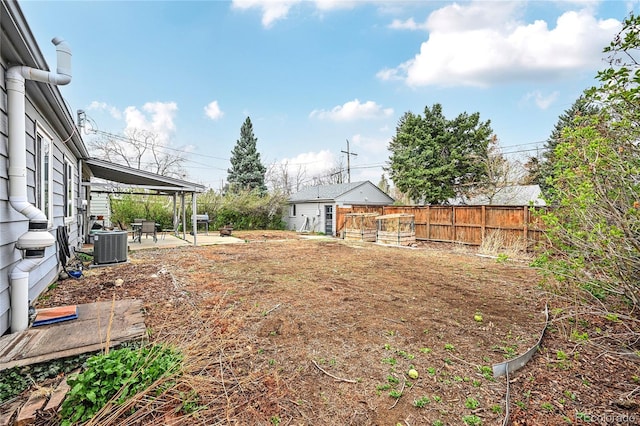 view of yard with a patio, central AC unit, fence, and an outdoor structure