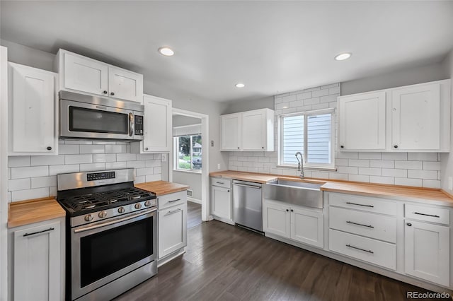 1801 S Eudora St, Denver, CO 80222 - kitchen featuring wooden counters, stainless steel appliances, a sink, backsplash, and white cabinetry