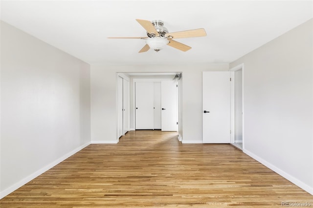 spare room with baseboards, ceiling fan, and light wood-style flooring