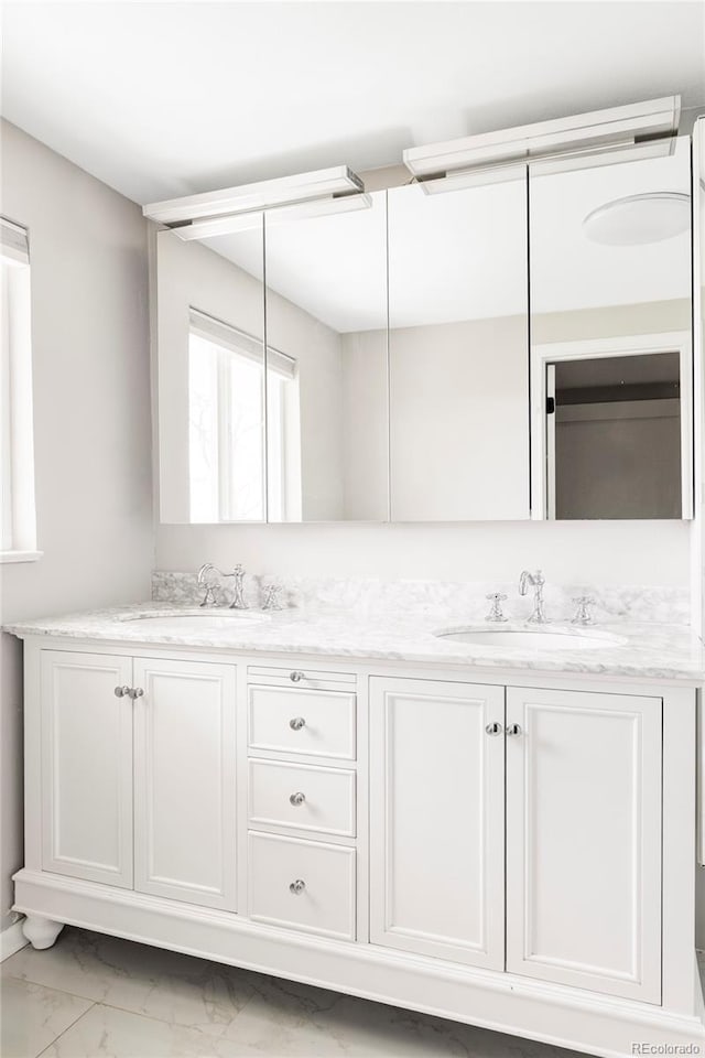 full bathroom featuring double vanity, a sink, and marble finish floor