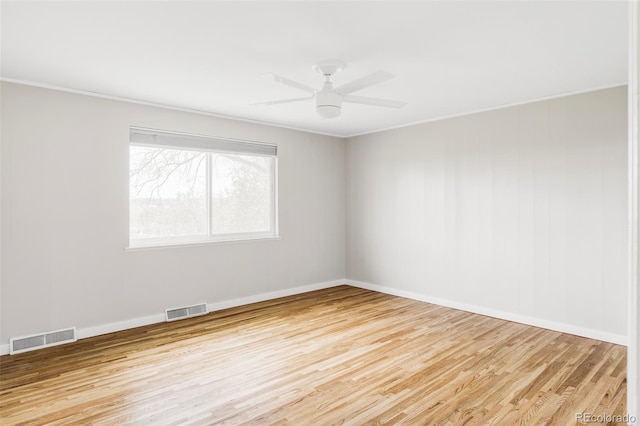 spare room with visible vents, baseboards, and wood finished floors