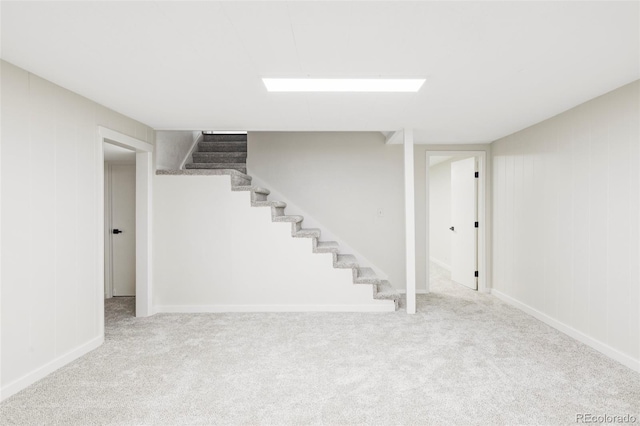 finished below grade area featuring stairs, baseboards, and carpet