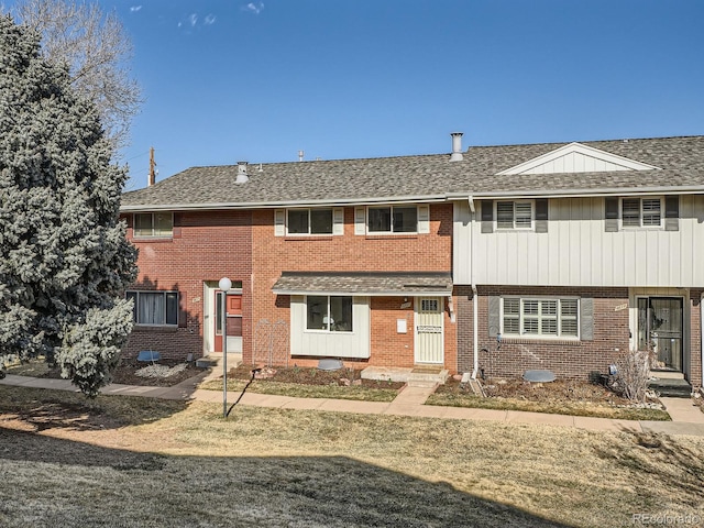 townhome / multi-family property with brick siding and roof with shingles