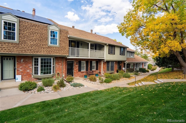 view of property featuring a front yard and solar panels