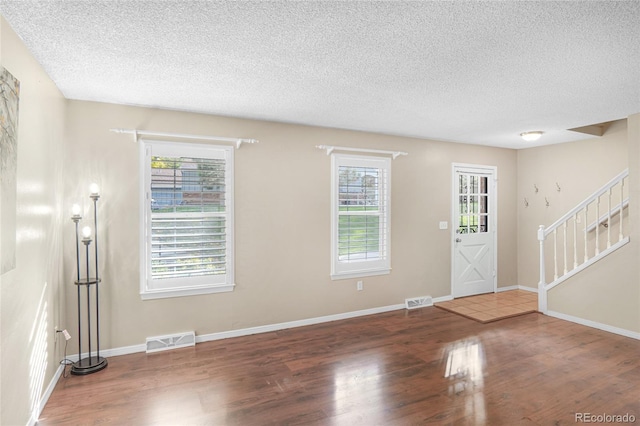 foyer featuring dark hardwood / wood-style floors and a textured ceiling