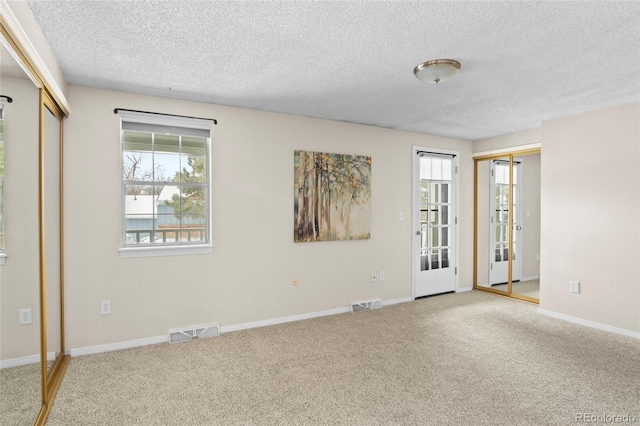 carpeted spare room featuring a textured ceiling